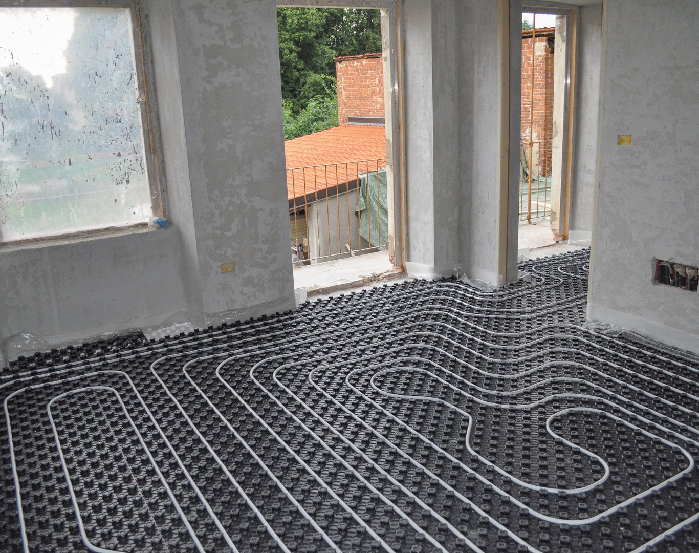 Geothermal Heating and Cooling in Haddonfield - NJ being installed beside a home with technicians connecting interior equipment